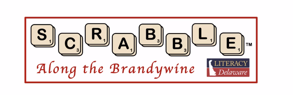 Logo with Scrabble letter tiles spelling SCRABBLE, red script text reading Along the Brandywine, and the Literacy Delaware logo in the corner.